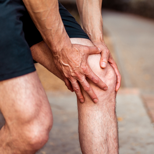 man holding his knee in pain