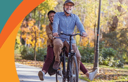 couple riding a bike through the trees