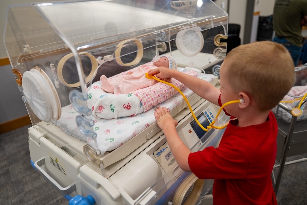 A child cares for a baby doll at the 2026 NICU Reunion