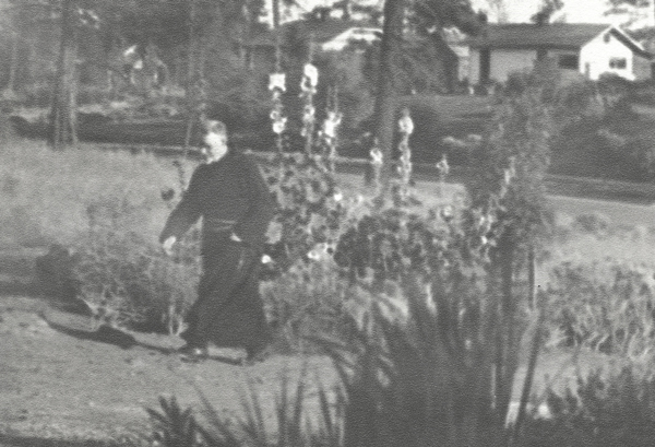 Father Sheehan walking through garden