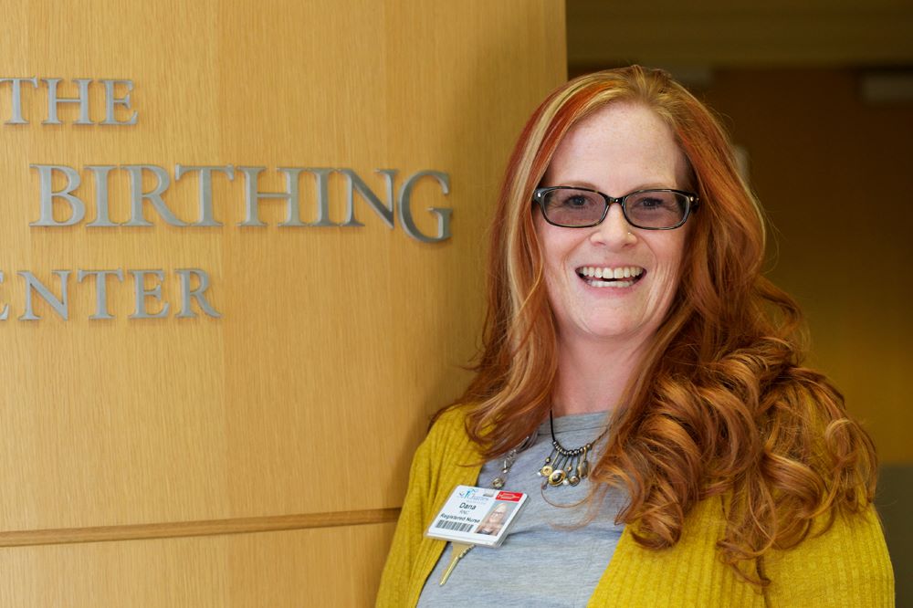 Dana standing in front of Family Birthing Center sign