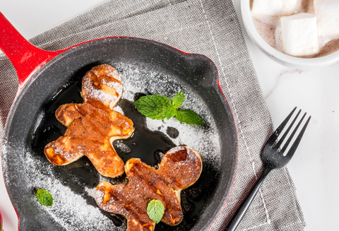 two gingerbread man pancakes in skillet