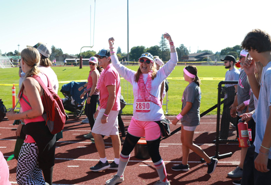 woman running with hands up at the Heaven Can Wait 5K