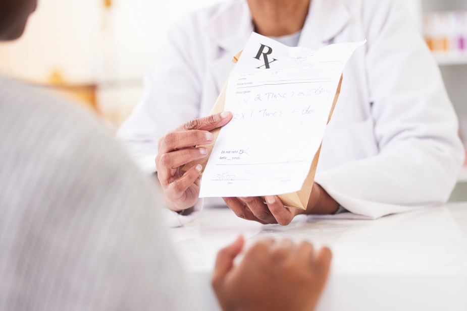 pharmacist holding up a prescription sheet