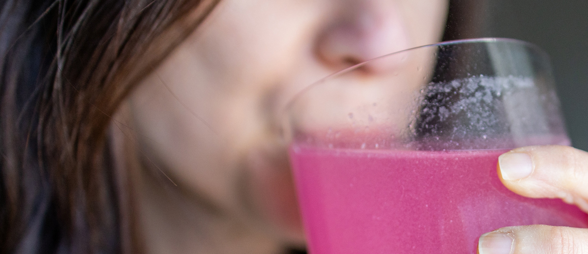 woman drinking pink drink
