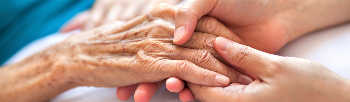 patient hand holding a caregiver's hand