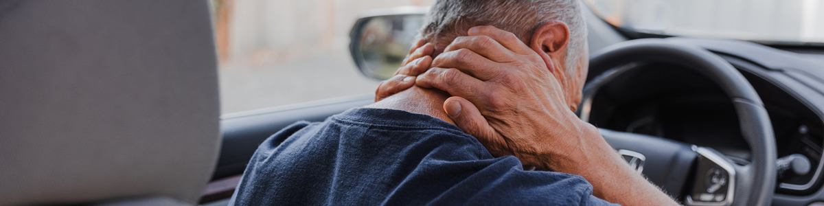 man holding neck while sitting in car